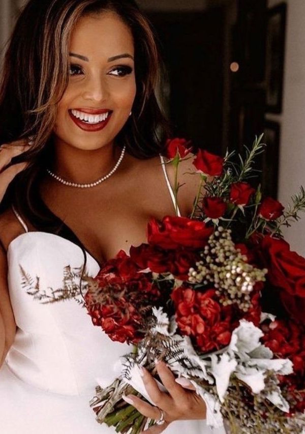 Bride holding a bouquet of red roses at her wedding - D&D